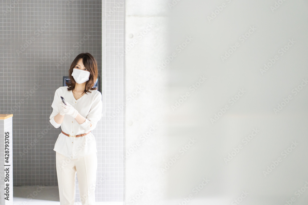 感染拡大防止のためにお客様の体温を計測するスタッフ 感染拡大防止のためにお客様の体温を計測するスタッフ