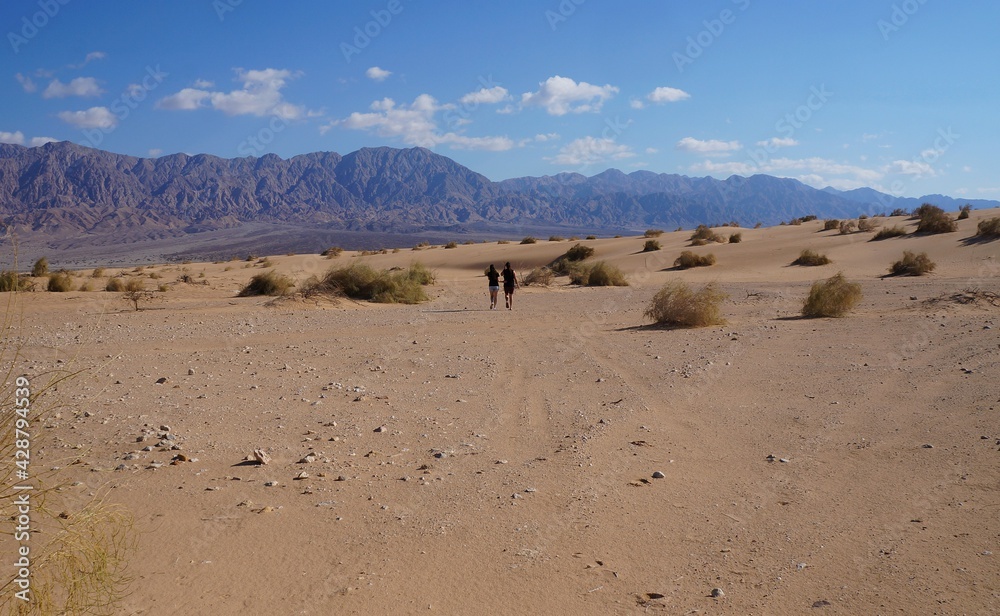 Young beautiful couple enjoys their hiking in the wild desert