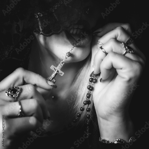 mujer sin rostro moderna rezando con mantilla anillos y un rosario Stock  Photo | Adobe Stock