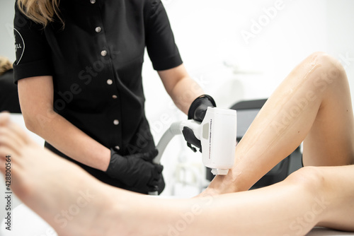 Cosmetology. Young Woman With Beautiful Body At Spa Salon Receiving Laser Hair Removal Procedure. Beautician Using Modern Apparatus For Spa Procedures. Skin And Beauty Care.