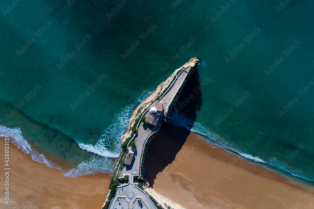 Aerial drone photo of the beautiful Praia da Senhora da Rocha (Senhora da Rocha Beach) with the white chapel on the roks, near Armacao de Pera, Algarve, Portugal