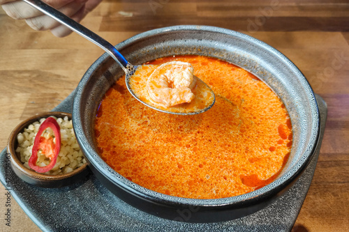 Obraz na plátně Bowl wuth a hot delicious tom yum soup and a spoone with a shrimp