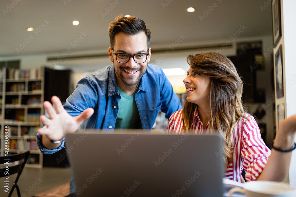 Happy young people working together on laptop. Teamwork, study, technology, office concept Happy young people working together on laptop. Teamwork, study, technology, office concept