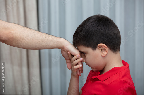 Little boy kiss his father's hand during Eid mubarak (Turkish Ramazan or Seker Bayram). Adorable child kiss elderly man hand to show respect. Cute toddler follow muslim Ramadan traditions photo