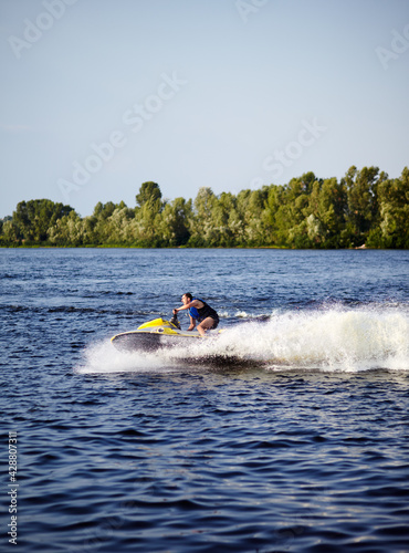 Man speeding on jet ski on lake during summer vacation