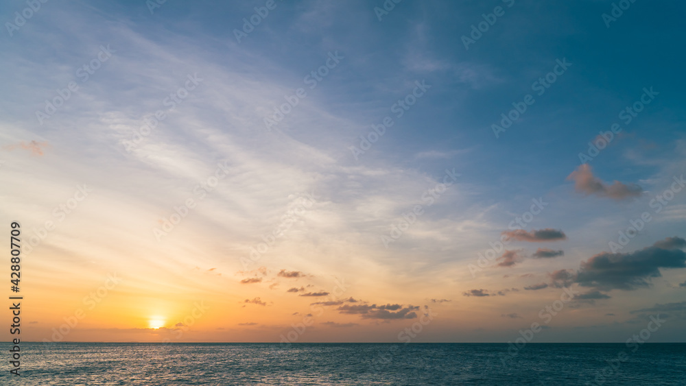 Sunset sky over sea in the evening with colorful orange sunlight, Dusk sky background.
