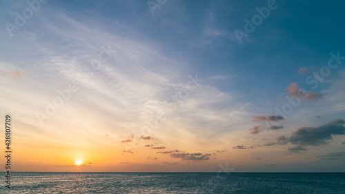 Sunset sky over sea in the evening with colorful orange sunlight, Dusk sky background. © Nature Peaceful 