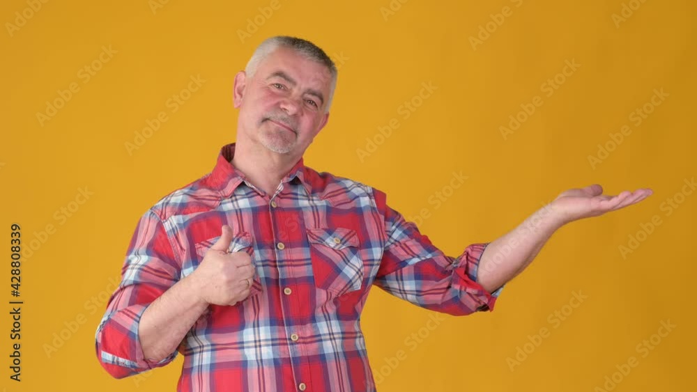Attractive middle-aged man holding free space for your advertising content showing thumbs up Attractive middle-aged man holding free space for your advertising content showing thumbs up