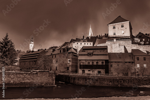 Bystrzyca Klodzka, a night panorama of the city on the Nysa Klodzka River. View of the old town buildings on a winter night.