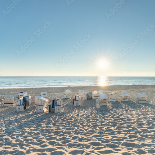 Fototapeta Naklejka Na Ścianę i Meble -  Empty roofed wicker beach chairs at the North Sea coast, Sylt, Germany