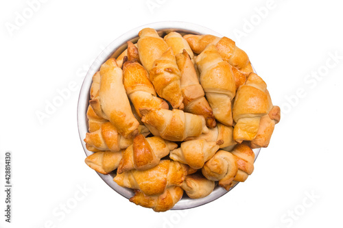 Croissants. Fresh homemade cakes in a heap in a metal dish on a white isolated background. Buns