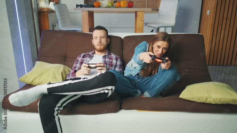 Emotional diverse gamers are holding joysticks and competition in intense video game on gaming console. The woman is winning the game. Concept of gaming addiction and entertainment. Emotional diverse gamers are holding joysticks and competition in intense video game on gaming console. The woman is winning the game. Concept of gaming addiction and entertainment.