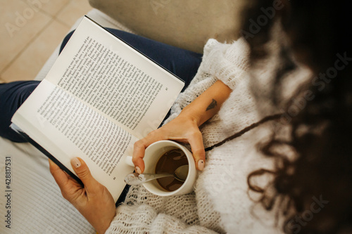 woman reading a book with a coffee