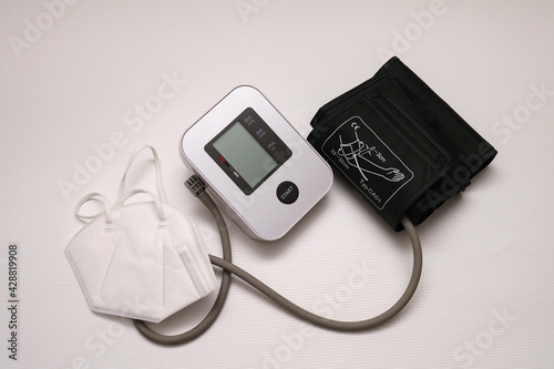 Pressure measuring device and medical mask on a white table.