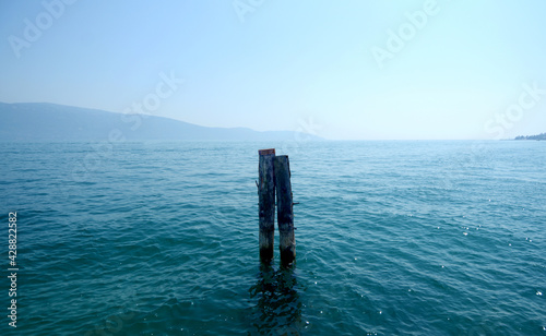 Pole moorings on Lake Garda that look like souls of embraced bodies 