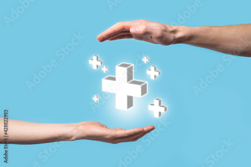 Hand hold 3D plus icon, man hold in hand offer positive thing such as profit, benefits, development, CSR represented by plus sign.The hand shows the plus sign