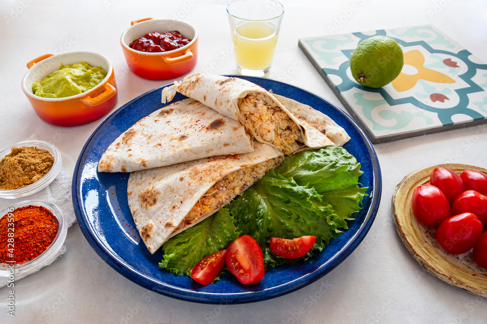 Close-up of Mexican quesadillas, with guacamole, tomatoes and spices