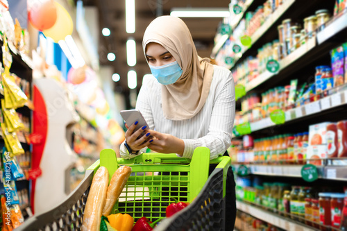 Islamic Female On Grocery Shopping In Supermarket Using Smartphone