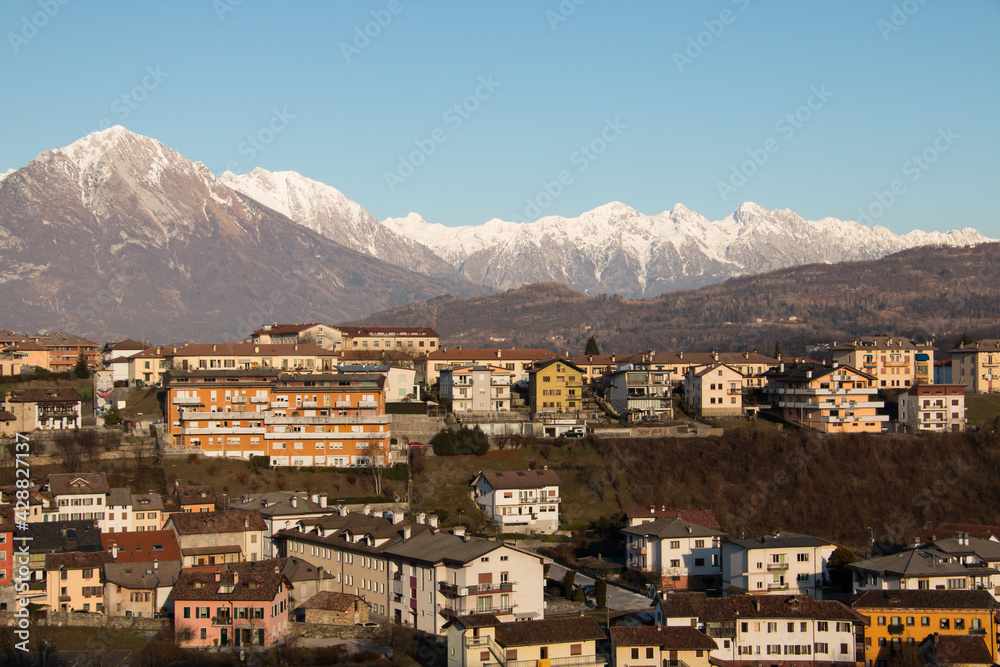 paisaje pueblo de montaña desde lo alto con picos nevados de fondo