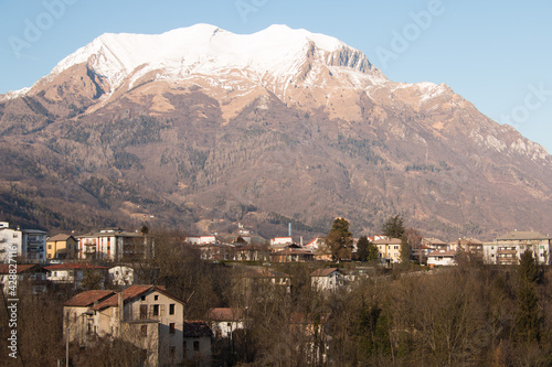 paisaje pueblo de montaña desde lo alto con picos nevados de fondo