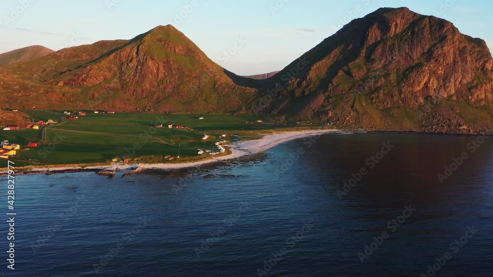 Wide Aerial View of Sunny Uttakleiv Beach, Mountains and Calm Oceanic Waters Wide Aerial View of Sunny Uttakleiv Beach, Mountains and Calm Oceanic Waters