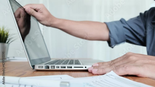 Work from home close up Asian businessman opening laptop computer typing information work planning strategy business finance, in quarantine lockdown coronavirus covid-19 pandemic, working home office