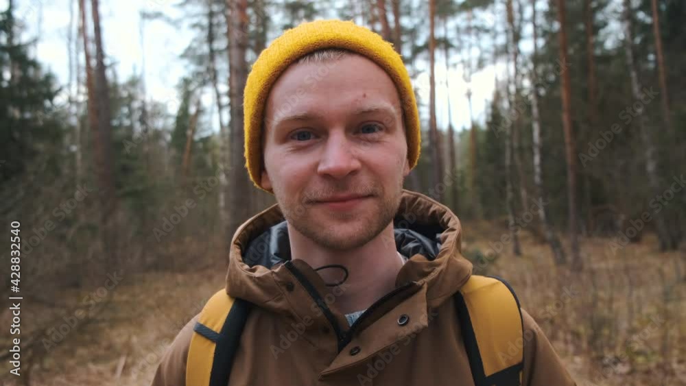 Young happy beautiful male smiling standing on the forest road. Enjoying the sun. High quality 4k footage Young happy beautiful male smiling standing on the forest road. Enjoying the sun. High quality 4k footage