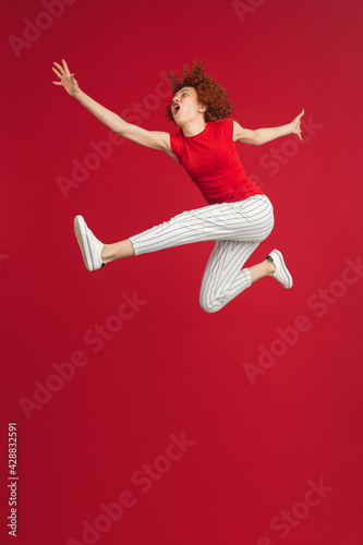Caucasian woman's portrait isolated over red studio background with copyspace