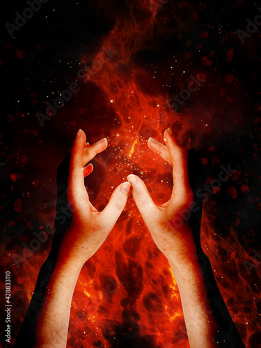 Woman's hands raised in worship and celebration of the Beltane festival in May. Traditional gathering for pagans and wicca marked with the lighting of fires through the night