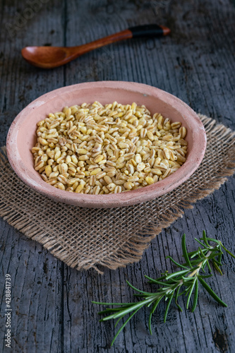 Uncooked wheat grains grown in france on rustic background