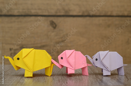 Three origami elephants follow in row © hachut