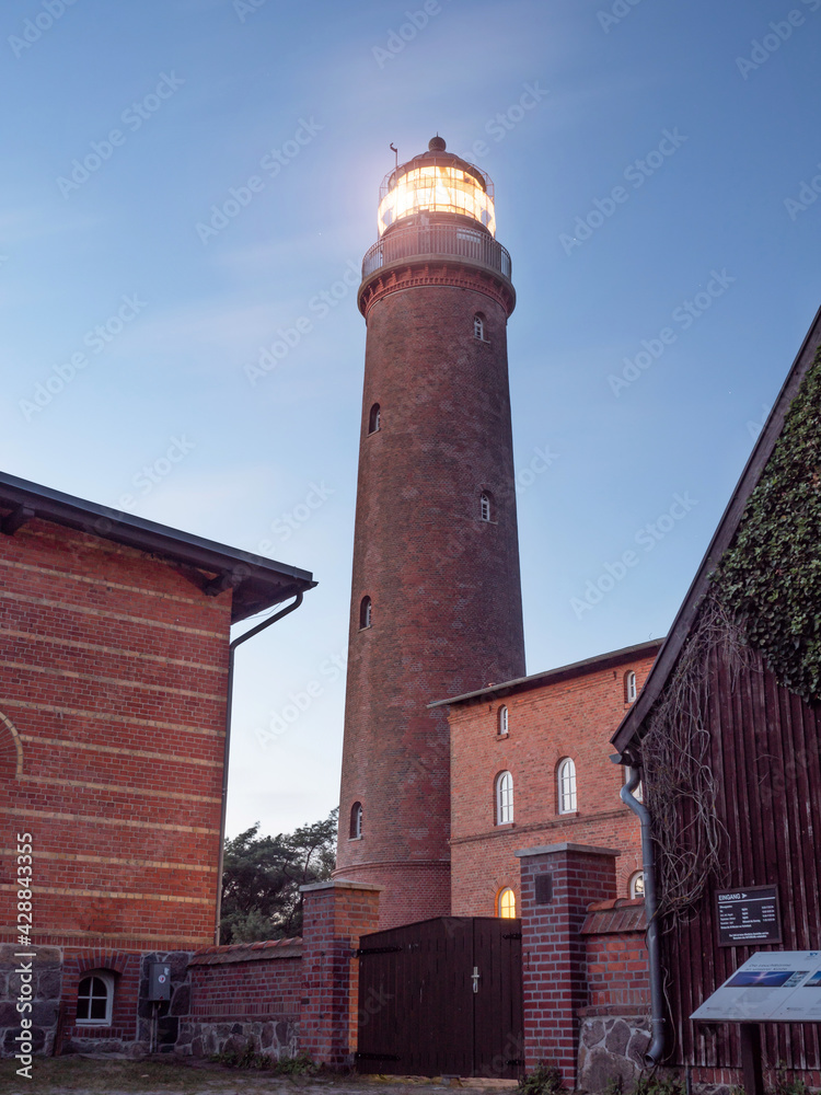 Shinning lighthouse in evening. Tower in park at Prerow