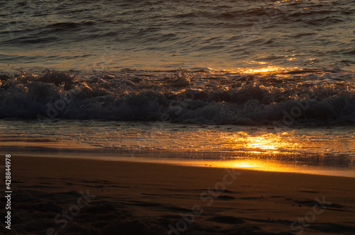 Fototapeta Naklejka Na Ścianę i Meble -  Sunset on the Baltic Sea. Golden sand and splashing waves. Beautiful view. 