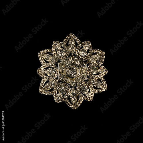 Fototapeta Naklejka Na Ścianę i Meble -  Round antique brooch with precious stones and crystals in the shape of a flower. Vintage brooch in the shape of a flower