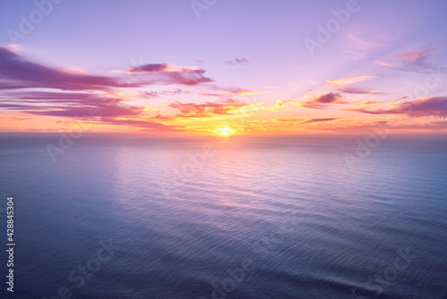 pink sunset seascape, sun above horizon