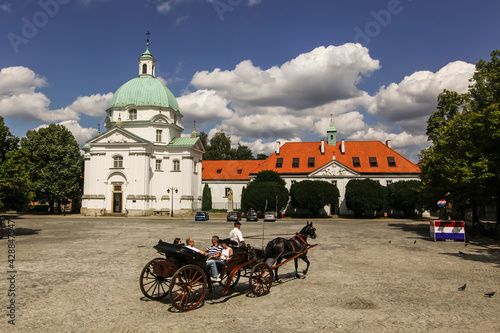 Tourist horse-drawn carriage on New Town Market with Benedictine Monastery in Warsaw, Poland. June 2012