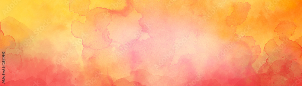 Abstract watercolor background in autumn colors of yellow orange red and pink with painted texture, bright colorful blotches and blobs stain the border of the paper