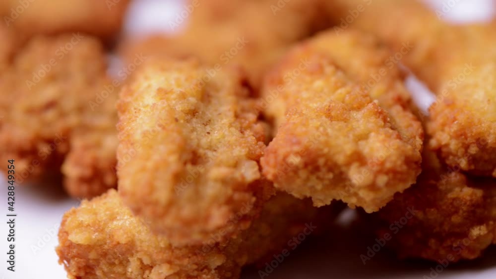 macro closeup of chicken nuggets snacks rotating spinning on a dish macro closeup of chicken nuggets snacks rotating spinning on a dish