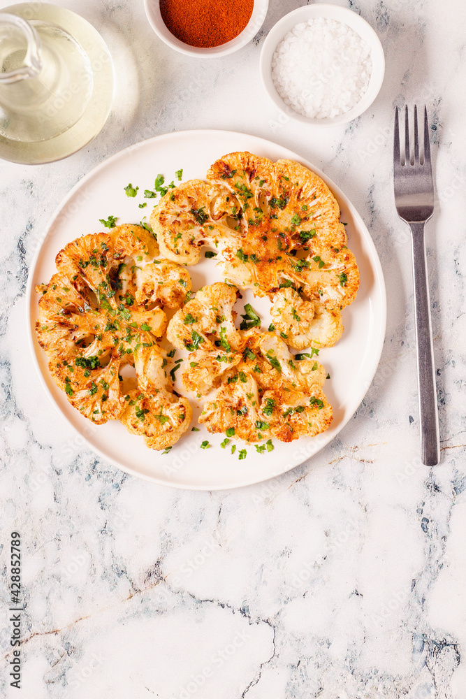 Cauliflower steak with spices cooked in the oven, top view. Cauliflower steak with spices cooked in the oven, top view.