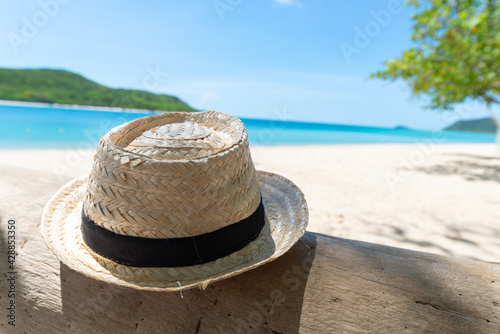Straw hat on the timber with beach and seaside fresh sky background. Holiday and Vacation concept. Chilling and Relax concept. Fresh Holiday. Summertime. Copy space for message. © setthawuth