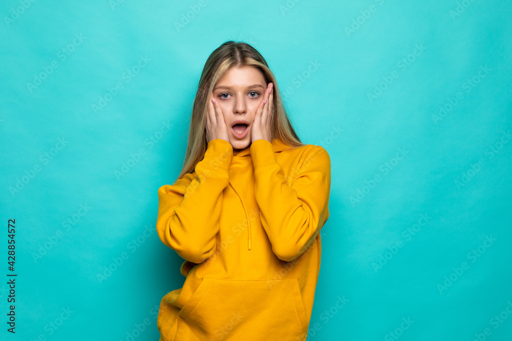 Portrait of pretty screaming wonder woman wearing white t-shirt isolated over turquoise background Portrait of pretty screaming wonder woman wearing white t-shirt isolated over turquoise background