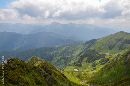 Summer landscape with hills, trails and peaks on the horizon Morning in Marmarosy ridge, Carpathian Mountains. Ukraine.