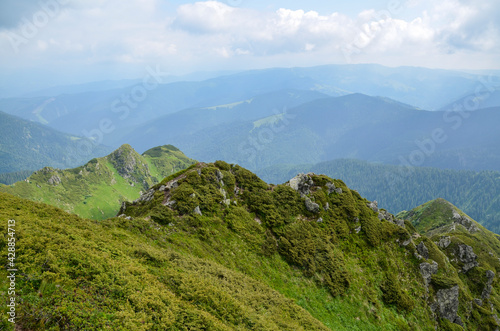 Summer landscape with hills, trails and peaks on the horizon Morning in Marmarosy ridge, Carpathian Mountains. Ukraine. 