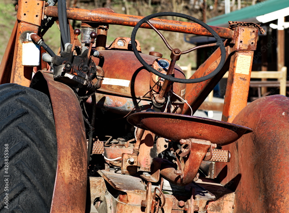 Close up on an old rusty tractor sitting in an orchard. Close up on an old rusty tractor sitting in an orchard.