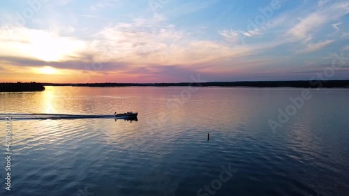 Christ Craft Boat going across screen during sunset.