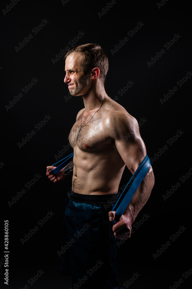Man on black background keeps dumbbells pumped up in fitness active chest black, athlete muscular workout athletic healthy pectoral. handsome adult, gym fit With a ribbon in hand, the fitness gum is Man on black background keeps dumbbells pumped up in fitness active chest black, athlete muscular workout athletic healthy pectoral. handsome adult, gym fit With a ribbon in hand, the fitness gum is