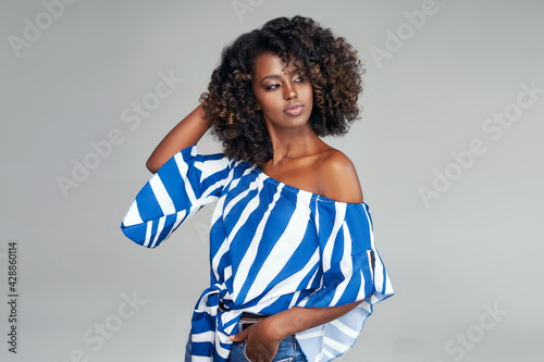 Beautiful african american model with afro hair isolated on gray
