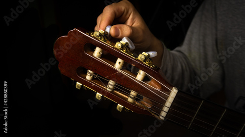 Macro shot of Man tuning the guitar