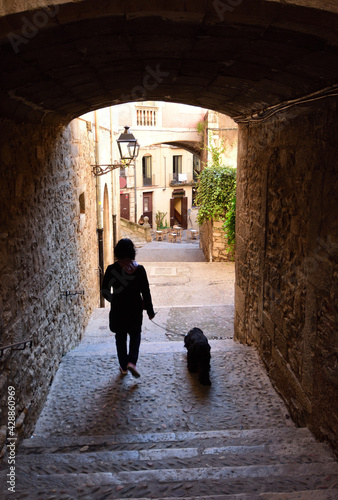 tourist walking  in the Arch in the street of Pujada de Sant Domenech, Agullana Palace in the background old town of Girona, Catalonia, Spain photo