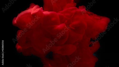 Red ink splash in water on black background
